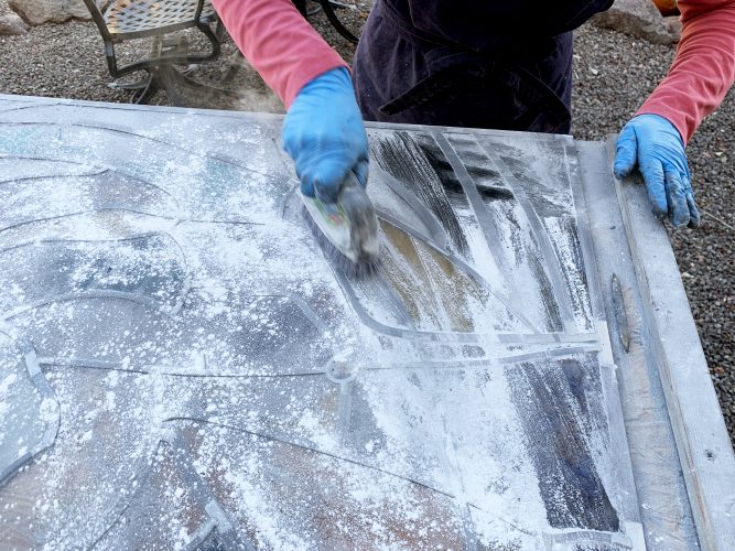. . . cleaning is a dry process. Whiting (powdered CaCO3/chalk) is sprinkled over panel and scrubbed with a stiff brush. . .